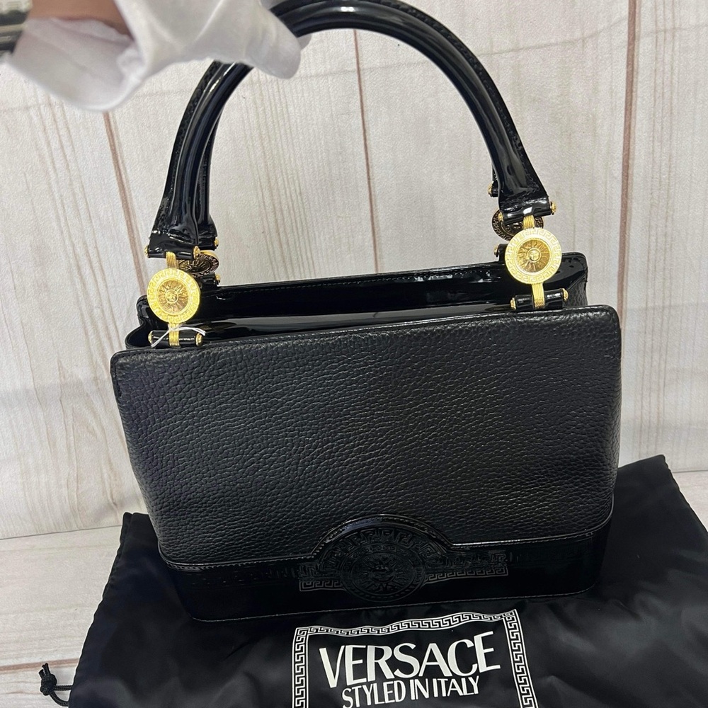 Elegant black Versace handbag with gold accents.